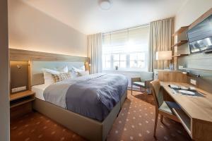 een hotelkamer met een groot bed, een bureau en een bureau bij Struck Landhotel & SPA in Attendorn