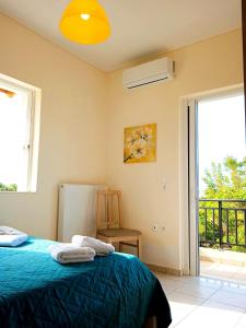 a bedroom with a blue bed and a balcony at Mochlos Essence Apartments in Mochlos