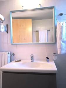 a bathroom with a sink and a mirror and towels at Mochlos Essence Apartments in Mochlos