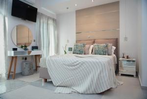 a bedroom with a large bed and a mirror at SM Luxury Penthouse Corfu in Ágios Rókkos