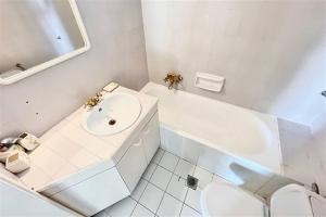 a white bathroom with a sink and a toilet at Nemesis House Elani Beach in Elani