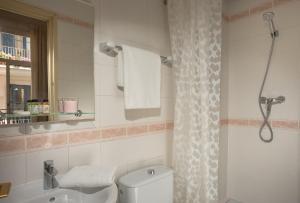 La salle de bains est pourvue de toilettes, d'un lavabo et d'une douche. dans l'établissement Antonios Hostal, à Sitges