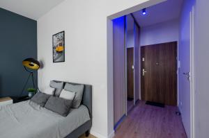 a bedroom with a bed and a room with purple walls at Apartament Majowy in Łódź