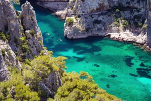 an aerial view of a blue lagoon between two cliffs at Cosy Lodge Sainte Baume in Nans-les-Pins