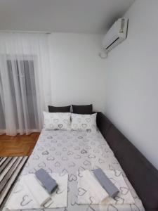 a bedroom with a bed with blue towels on it at Apartman MiS Trebinje in Trebinje