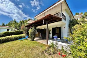 a house with a porch and chairs on a yard at Nemesis House Elani Beach in Elani