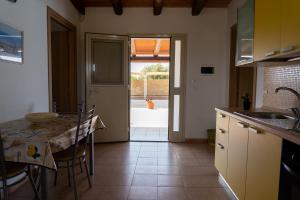 a kitchen with a table and a dining room at B&B L'Uliveto in Marzamemi