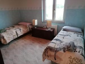 1 dormitorio con 2 camas y ventana en La casa degli ulivi, en Turri