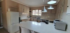 a kitchen with a counter and a white refrigerator at 3-Bedroom House, Greenway Woods, White River in White River