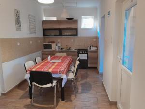a kitchen and dining room with a table and chairs at Vörösmarty Apartman in Dombóvár