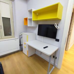 Zimmer mit einem Schreibtisch und einem TV an der Wand in der Unterkunft GIOIA SEA Apartment In Versilia in Viareggio