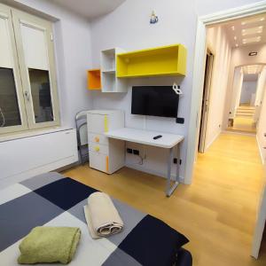 Kleines Zimmer mit einem Schreibtisch und einem TV. in der Unterkunft GIOIA SEA Apartment In Versilia in Viareggio