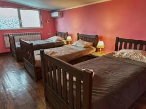 two beds in a room with red walls at НордВест in Yerevan