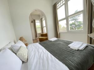 um quarto branco com uma cama grande e 2 janelas em Ikigai Hotel Villa Rıfat em Adalar