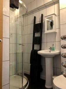 a bathroom with a glass shower and a sink at Bank Building Apartments in Barnoldswick