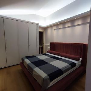 ein Schlafzimmer mit einem Bett mit einer karierten Decke in der Unterkunft GIOIA SEA Apartment In Versilia in Viareggio