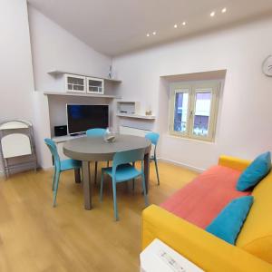 ein Wohnzimmer mit einem Tisch, Stühlen und einem Sofa in der Unterkunft GIOIA SEA Apartment In Versilia in Viareggio