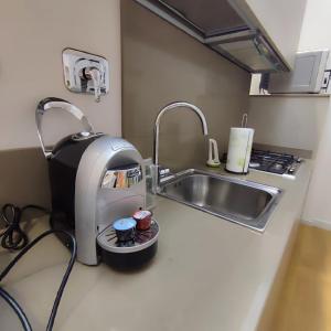 eine Küchentheke mit einem Mixer und einem Waschbecken in der Unterkunft GIOIA SEA Apartment In Versilia in Viareggio