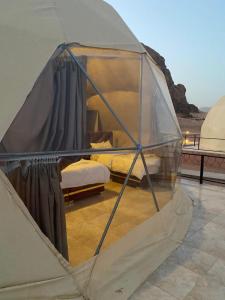 Zimmer mit einem Zelt mit einem Bett in der Unterkunft Bubbles Oasis Camp Wadi Rum in Wadi Rum