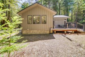 ein winziges Haus im Wald mit einer Veranda in der Unterkunft Peaceful Mendocino Cottage Surrounded By Redwoods in Mendocino