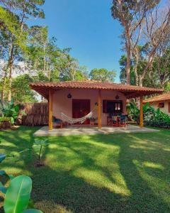 a house with a hammock in a yard at Vila dos Macacos Trancoso in Trancoso
