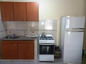 eine Küche mit einem weißen Herd und einem Kühlschrank in der Unterkunft Departamento Villa Libertad in Leandro N. Alem + 3 Fotos