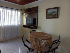une salle à manger avec une table, des chaises et une télévision dans l'établissement Departamento Villa Libertad, à Leandro N. Alem