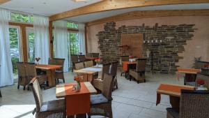 a restaurant with tables and chairs and a stone wall at Naturhotel Forsthaus in Annaberg-Buchholz