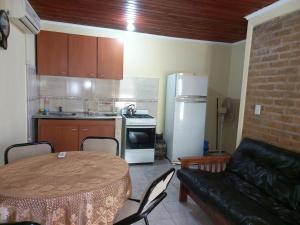 Leandro N. Alem的住宿－Departamento Villa Libertad，一间带桌子的客厅和一间带冰箱的厨房