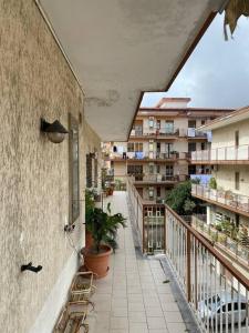 a balcony with chairs and plants on a building at B&G large and bright apartment in Cava deʼ Tirreni