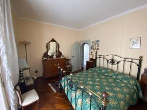 1 dormitorio con cama, espejo y silla en B&G large and bright apartment en Cava deʼ Tirreni