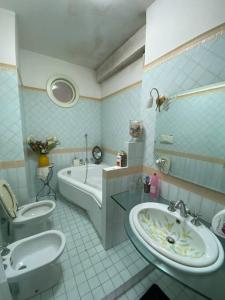 y baño con lavabo, bañera y aseo. en B&G large and bright apartment en Cava deʼ Tirreni