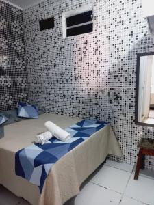 um quarto com uma cama com lençóis azuis e brancos em Casa da Lis pé na areia em Morro de São Paulo