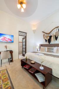 a bedroom with a bed and a table and a desk at Casa Dos Lirios Hotel Boutique in Mérida