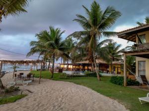 um resort na praia com palmeiras em Eden One em Ilhéus