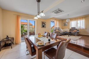 a dining room and living room with a table and chairs at Apartment Anchor in Šibenik