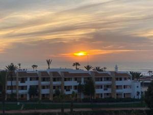 a building with the sunset in the background at La Suite Hotel Agadir Adults Only in Agadir