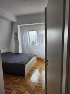 um quarto com uma cama e piso em madeira em ONE bedroom apartment - close the CITY CENTER! PRISHTINA em Pristina