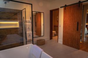 uma casa de banho com uma banheira e um chuveiro em vidro. em Saison Resort & Spa em Itaipava