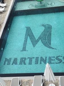 Martiness Hotel Durres في دوريس: حمام سباحة مع وجود علامة M على الصيانة الجماعية