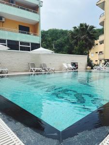 een groot zwembad met blauw water voor een gebouw bij Martiness Hotel Durres in Durrës