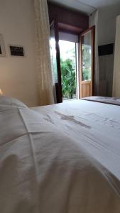 a bedroom with a white bed with a window at Maison Lido Silvana in Pulsano