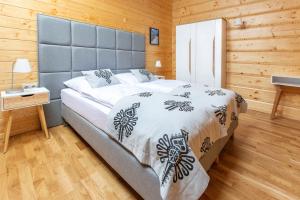 a bedroom with a large bed in a wooden room at Hyrna Chata Relaks&SPA in Maniowy