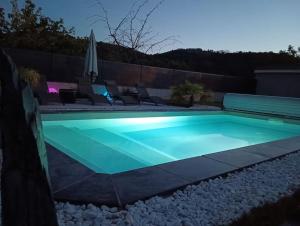 uma piscina iluminada à noite em CHAMBRE & SDB PRIVÉE avec piscine en bord de Via Rhona em Sarras