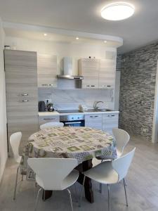a kitchen with a table and chairs in a kitchen at Appartamento Incantevole 300m dal mare in Lignano Sabbiadoro