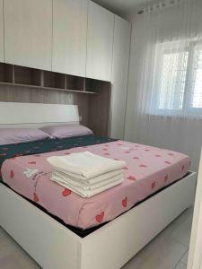 a bedroom with a bed with towels on it at Appartamento Incantevole 300m dal mare in Lignano Sabbiadoro +29 photos