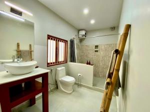 ein Bad mit einem Waschbecken, einem WC und einer Dusche in der Unterkunft Jetuka Villa - Sibsagar in Sibsāgar