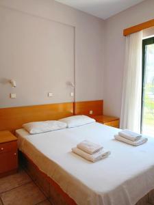 1 dormitorio con 1 cama blanca grande y toallas. en Captain's panoramic sea view en Sami