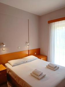 um quarto com uma cama com duas toalhas em Captain's panoramic sea view em Sami