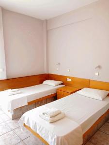 2 camas en una habitación con paredes blancas en Captain's panoramic sea view en Sami